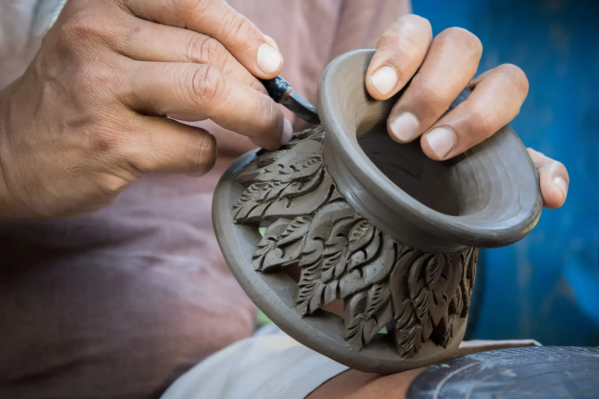 Mãos trabalhando uma peça artesanal, metáfora da obra-prima